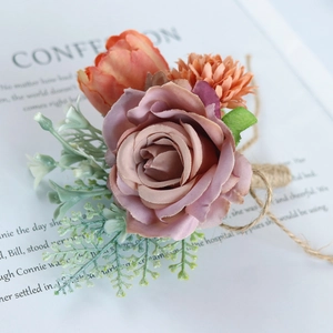 Groom's wedding boutonniere featuring silk roses, orange tulips and vintage twine wrap