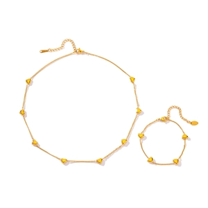 Golden stainless steel jewelry set with heart charms featuring necklace and bracelet