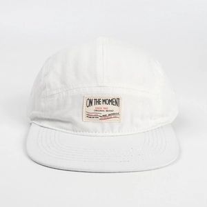 Dettaglio cappello bianco a 5 pannelli con etichetta vintage tessuta su tela di cotone