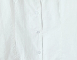 Detailed close-up of white woven cotton fabric texture and transparent round buttons