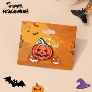 Detail of orange pumpkin ghost enamel pin on a festive Happy Halloween backing card