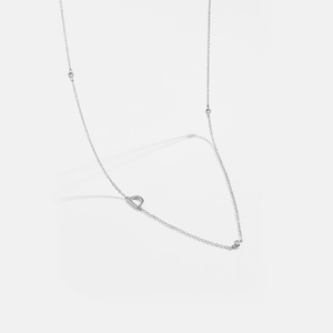 Macro shot of silver clavicle chain with D letter pendant and sparkling zircon accents