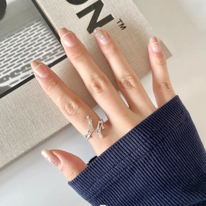 Detail of silver fluid irregular lava open ring with beads worn on index finger