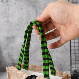 Close-up of Halloween tote bag showing green and black striped velvet handle and fabric texture