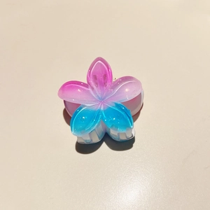 Close-up of a gradient acrylic frangipani hair claw with a translucent floral design