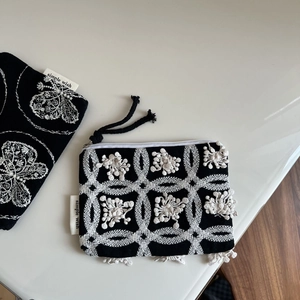 Minimalist black canvas coin purse with white floral embroidery and zipper closure