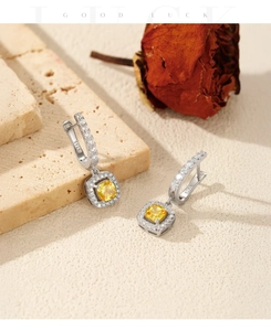 Detailed macro view of S925 sterling silver earrings with yellow square gemstones and pavé diamonds