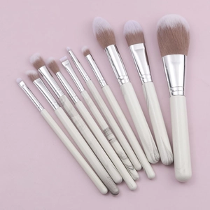 10-piece marble texture makeup brush set with silver ferrules on pink background
