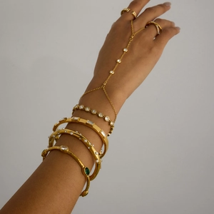Détail d'un bracelet bague doré orné de cristaux et de perles pour femme chic