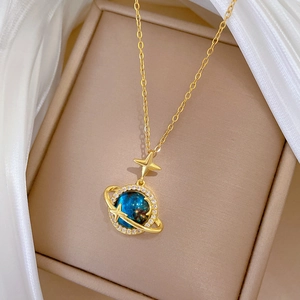 Dettaglio del ciondolo celeste dorato con sfera stellata blu e cristalli scintillanti