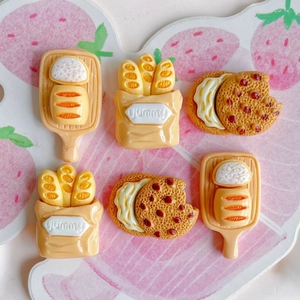 Macro detail of resin food charms featuring yummy baguettes, cookies and bread trays