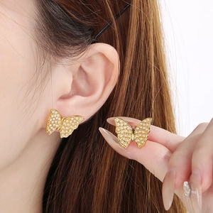 Close-up of butterfly earrings with white pearls in gold-plated stainless steel