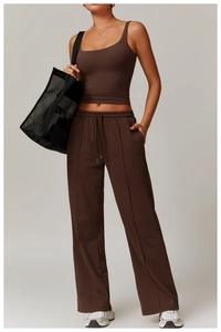 Détail d'un ensemble de yoga marron foncé avec un débardeur ajusté et un pantalon de sport large