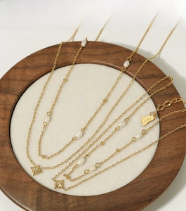 Detail of star pendant gold necklace with natural pearls and s.Steel hallmark logo