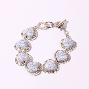 Close-up of retro heart-shaped turquoise stones and silver toggle clasp on bracelet