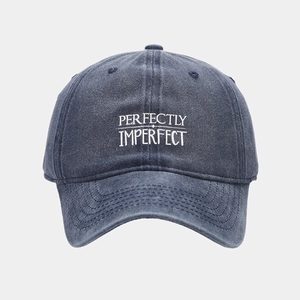 Detail of perfectly imperfect embroidery on navy blue washed cotton baseball cap