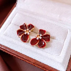 Elegant 18K gold plated red flower stud earrings with zircon centers in a jewelry box