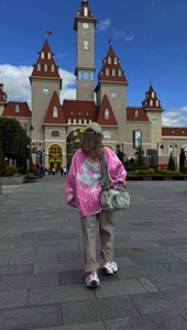 Rear view of pink knitted cardigan with blue geometric patterns in a scenic outdoor setting
