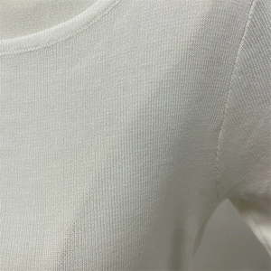 Close-up of the white knitted fabric texture and premium seam stitching detail