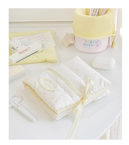 Detail of yellow and white striped fabric notebook cover with ribbon and brand label