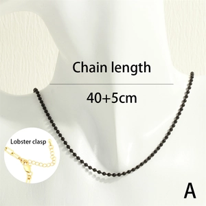 Detail of a black beaded necklace with a golden lobster clasp, length 40+5cm