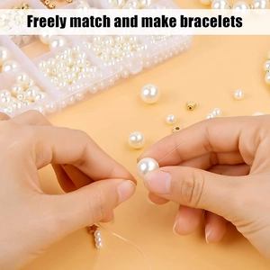 Detail showing hands crafting a DIY bracelet with white pearls and gold stars