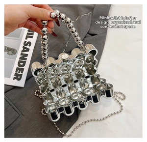Detail of silver geometric acrylic evening bag with bead handle and metal chain