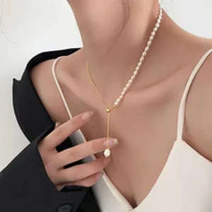 Dettaglio di una collana metà perle e metà catena dorata con perla barocca su modella