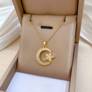 Detailed view of gold moon and star pendant with zircons in a jewelry gift box
