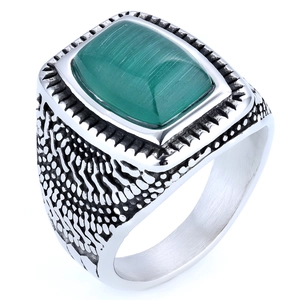 Close-up of vintage stainless steel ring with rectangular green stone and textured carving