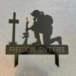 Close-up of laser-cut Freedom Isn't Free text on black metal soldier memorial stake