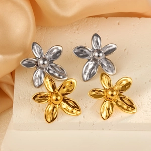 Orecchini a fiore in acciaio inossidabile oro e argento su sfondo di seta elegante