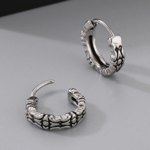 Detail of vintage silver-tone earrings with ornate floral patterns and leverback closure