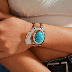 Close-up of a bohemian open-cuff bracelet with large oval turquoise stone on model