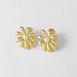 Vista detallada de pendientes florales bañados en oro de 18k con perlas blancas centrales