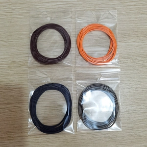 Detailed close-up of 1.7mm colorful carbon steel spring bracelets on a wooden surface