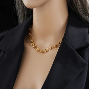 Golden titanium steel chunky knot necklace on model wearing black blazer for punk style