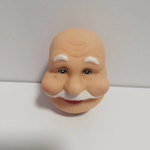 Macro shot of 3D vinyl Santa Claus head with white beard and blue eyes for DIY crafts
