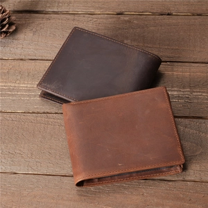 Detail of vintage genuine leather wallets in brown and dark brown on a wooden background