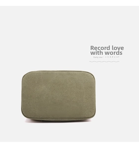 Detail shot of olive green canvas fabric texture and neat stitching on a sturdy handbag