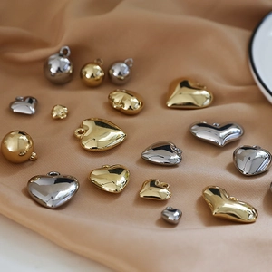 Detailed view of assorted gold and silver resin heart and ball charms on silk fabric