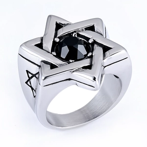 Macro shot of silver signet ring with black gem and engraved hexagram star side details