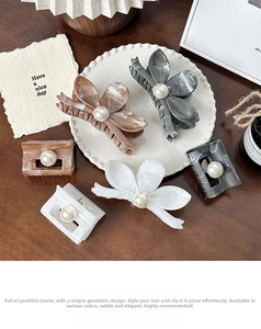Close-up of marble texture hair claws with pearls in a decorative ceramic plate