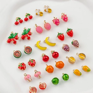 Macro view of assorted gold-plated fruit pendants including cherry and banana charms
