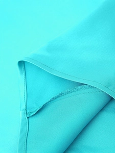 Gros plan détaillé du tissu satiné sarcelle lisse et des coutures précises de la robe