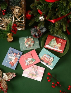 Close-up of Merry Christmas gift cards featuring Santa and tree with festive decor