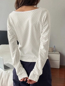 Vue arrière du haut blanc à manches longues avec pois noirs et texture en tissu doux