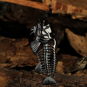 Macro view of black stainless steel fishbone pendant with cutout detail on wood