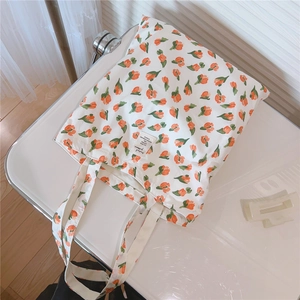 Detailansicht der weißen Canvas-Tasche mit orangefarbenem Tulpendruck und Webetikett