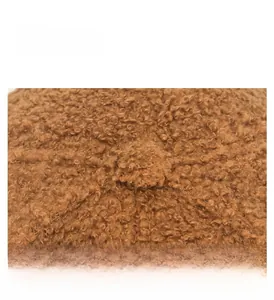 Close-up of brown teddy fleece baseball cap showing durable top button and fabric texture